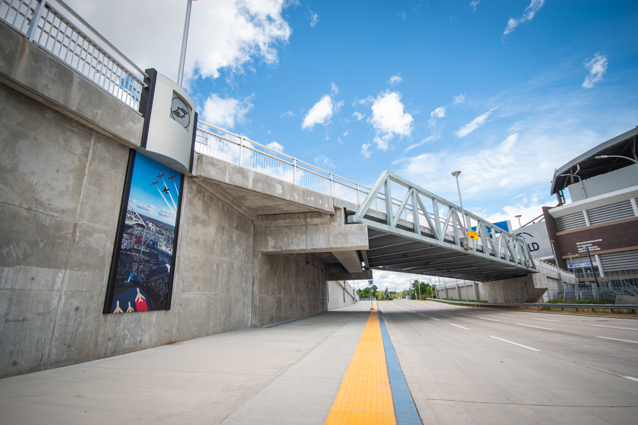 A trio of images taken during a Winnipeg Blue Bomber football game are displayed on a concrete wall